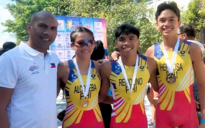 <p><strong>CHAMPION TEAM.</strong> Cebu bets rule the National Age Group Triathlon at Subic Bay Freeport in Zambales on Jan. 28, 2024. From left are coach Rolando Remolino and athletes Raven Faith Alcoseba (women's elite champion), Andrew Kim Remolino (men's elite champion) and Matthew Justine Hermosa (men's elite runner-up). <em>(PNA file photo by Jean Malanum) </em></p>