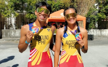 <p><strong>CHAMPS AGAIN.</strong> Cebuanos Andrew Kim Remolino (left) and Raven Faith Alcoseba show their gold medals after topping the elite category of the National Age Group Triathlon in Subic, Zambales on Sunday (Jan. 26, 2025). Remolino clocked 56 minutes and 46 seconds to keep the men's title while Alcoseba ruled the women's division in 1:05:19 to secure her fourth straight crown. <em>(PNA photo by Jean Malanum)</em></p>